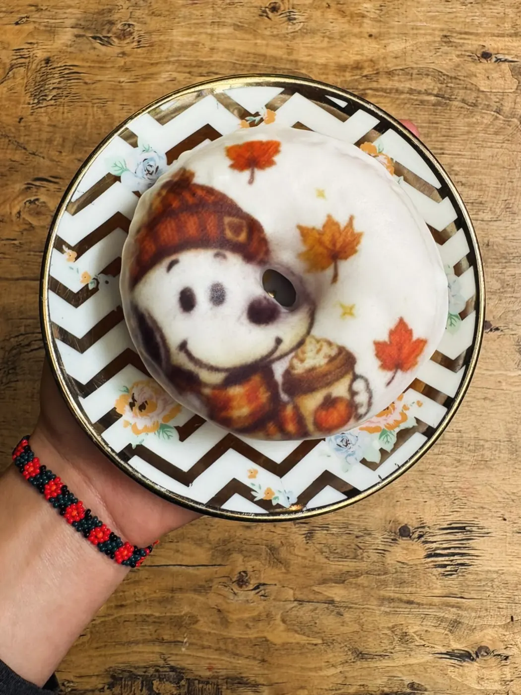 Taza con Snoopy de otoño impreso en la espuma, sobre un plato de zigzag